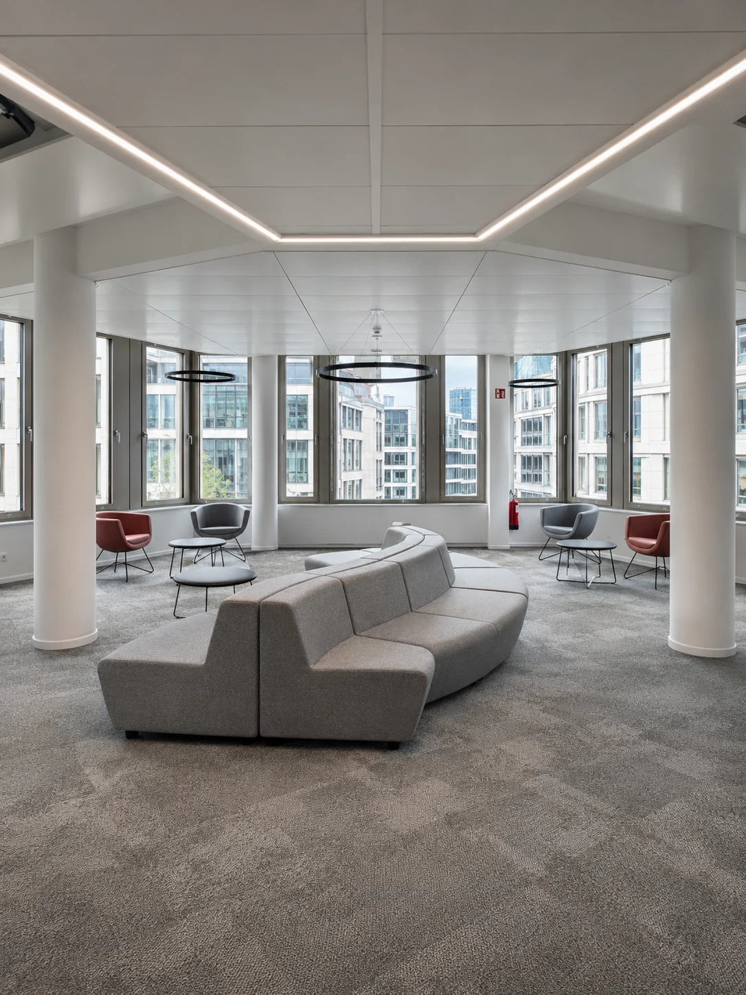 Lounge- und Wartebereich mit geschwungenem Sofa und Panoramafenstern